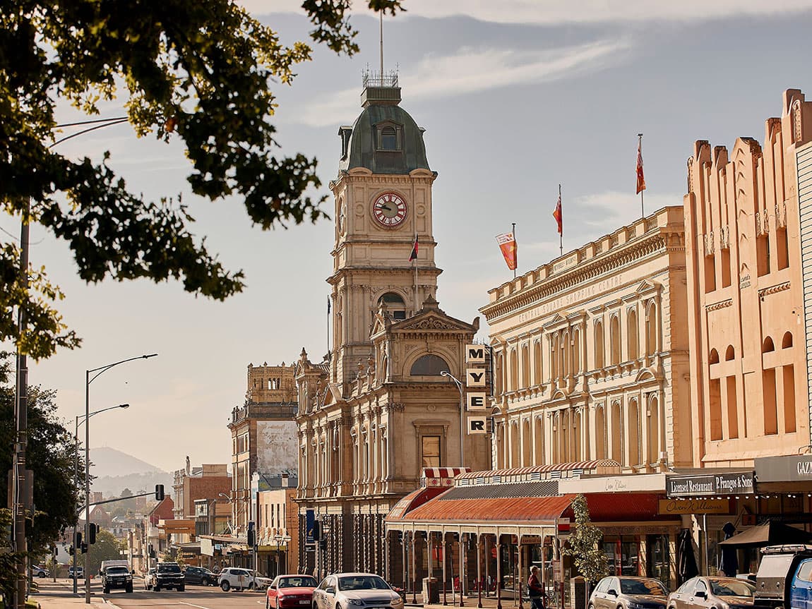 a busy city street with a clock tower in the background