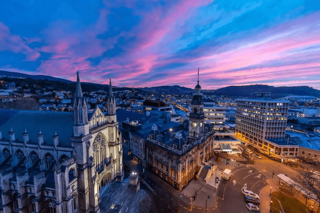 a city street lined with tall buildings and parked cars