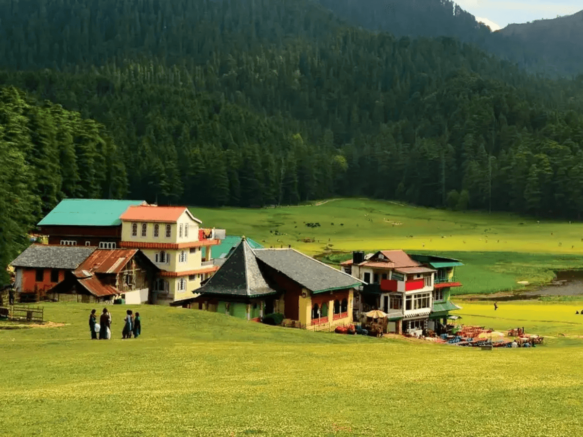 Mountains overlook a lush valley and greenery.
